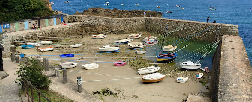 Grounded boats in a small harbor at low tide