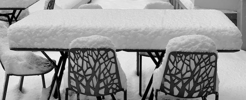 Table and chairs covered with snow